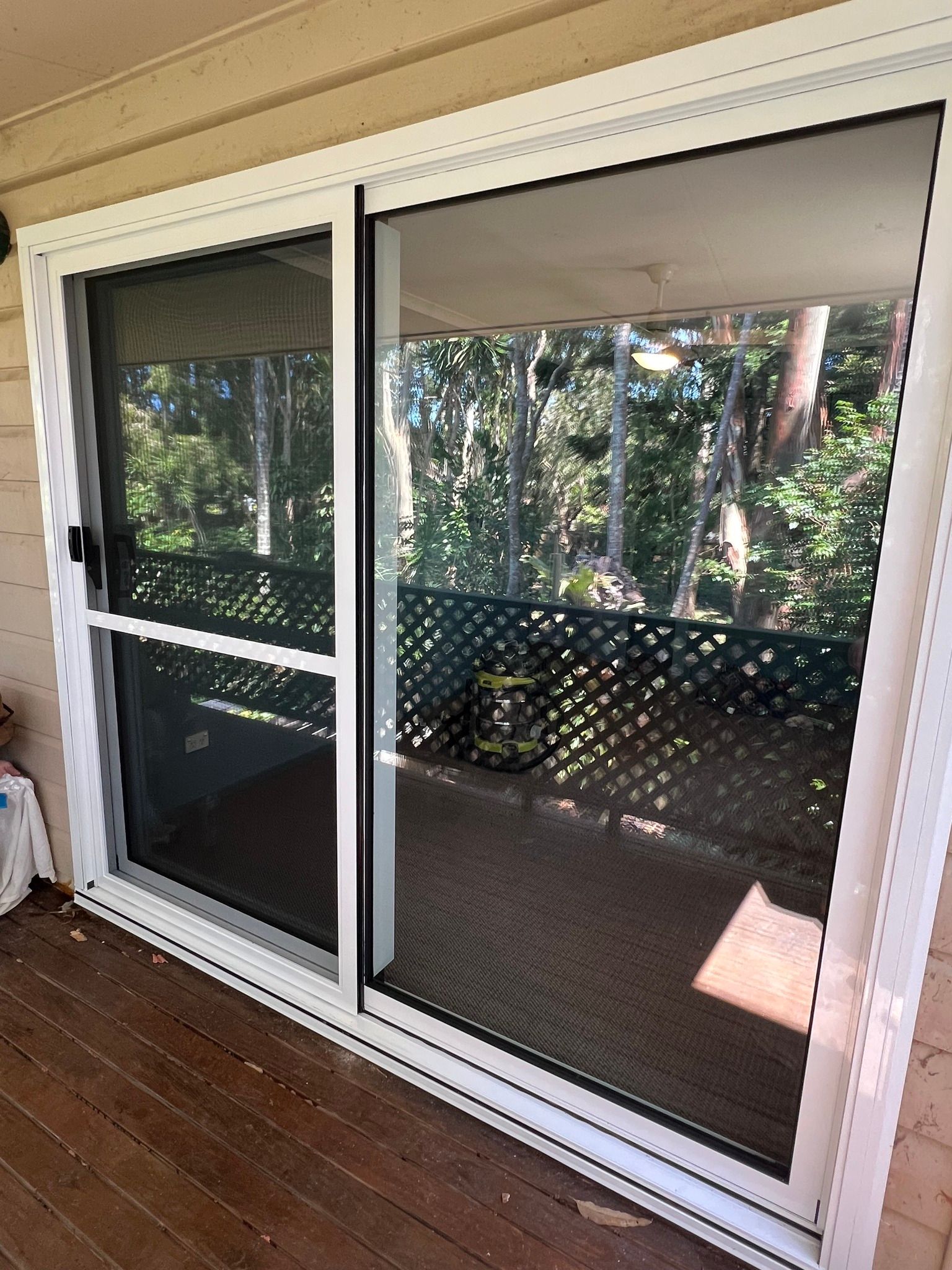 Sliding Glass Door With Screen Open, Overlooking a Deck and Trees — Datco Windows & Doors Pty Ltd In Coffs Harbour, NSW