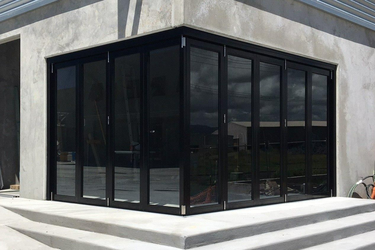 Black Framed Glass Folding Doors on a Corner of a Building — Datco Windows & Doors Pty Ltd In Toowoomba, QLD