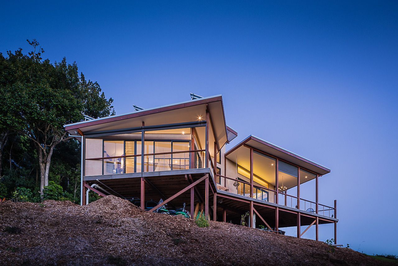A House is Sitting on Top of a Hill With Trees in the Background — Datco Windows & Doors Pty Ltd In South Murwillumbah, NSW