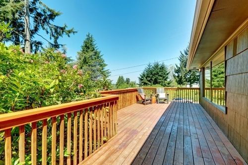 There is a large wooden deck with chairs on it.