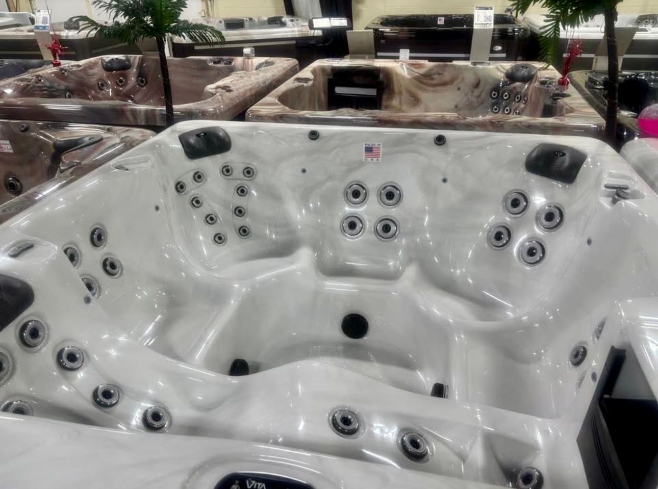 White hot tub with multiple jets in an indoor showroom
