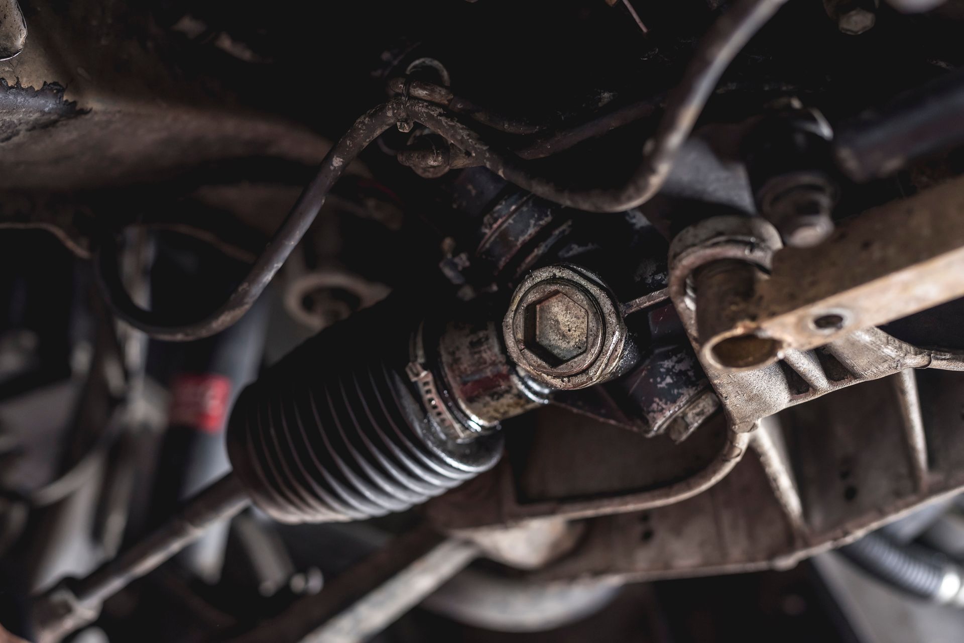 Close-up of a car steering rack and suspension components under the vehicle.