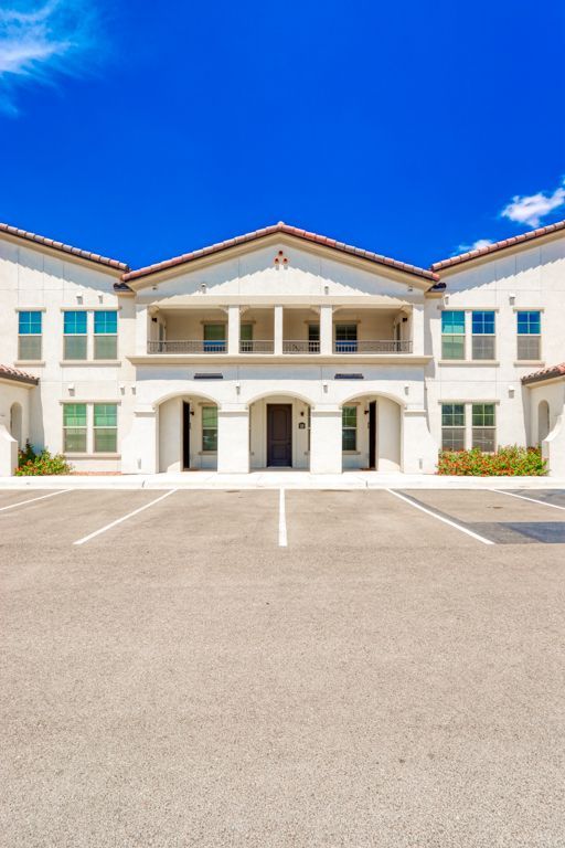 A large white building with a parking lot in front of it