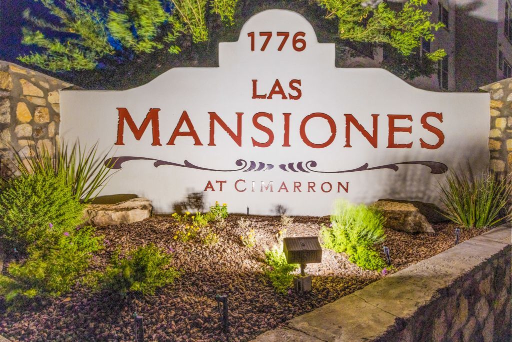 A sign for las mansiones is lit up at night