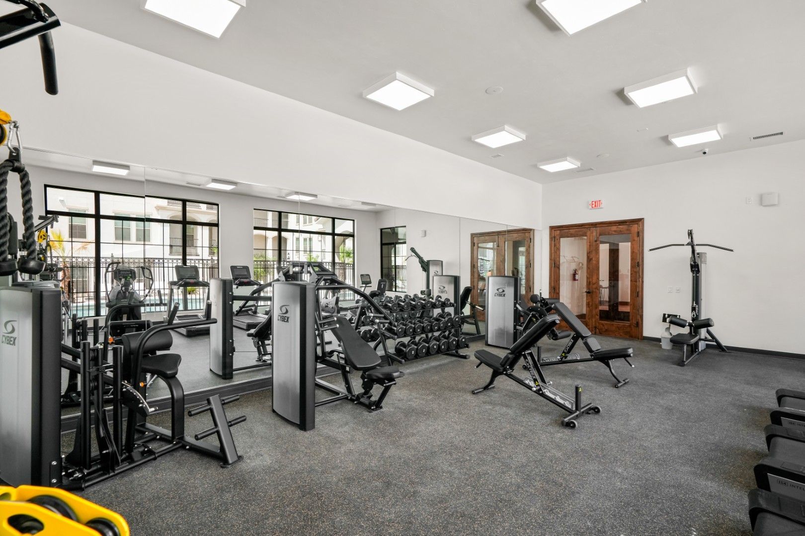 A large gym filled with lots of exercise equipment.