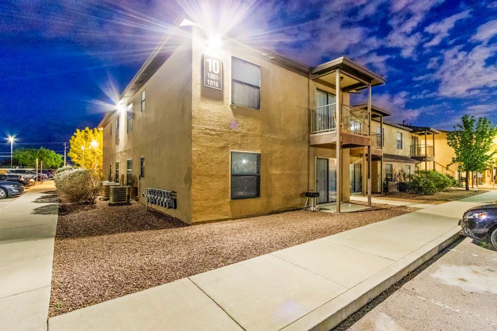 A large apartment building with a lot of windows is lit up at night.