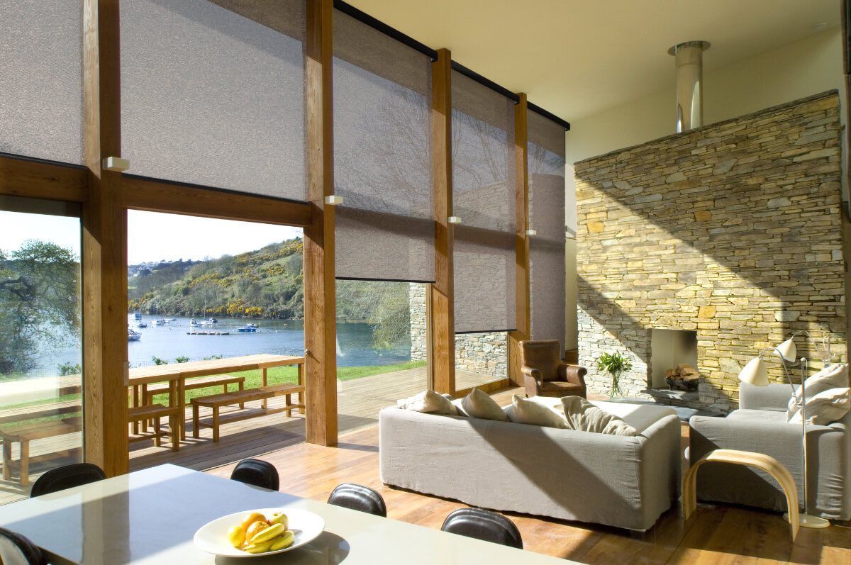 A living room with a lot of windows and a view of a lake