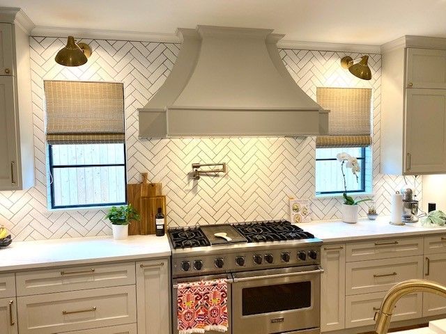 A kitchen with white cabinets, stainless steel appliances, and a stove top oven