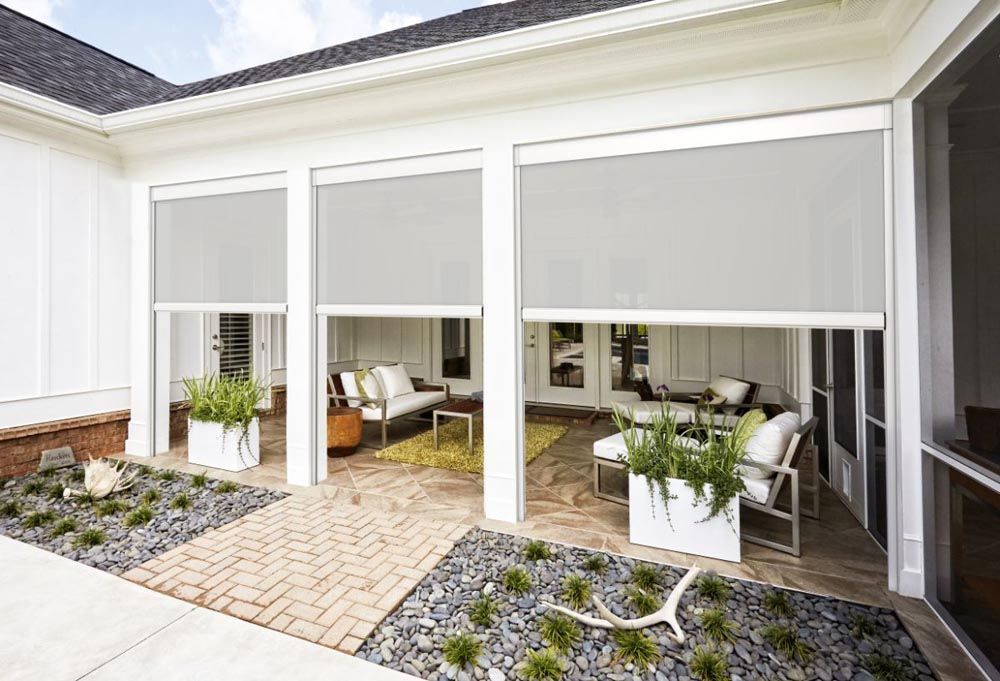 A screened in porch with a patio area and a couch and chairs