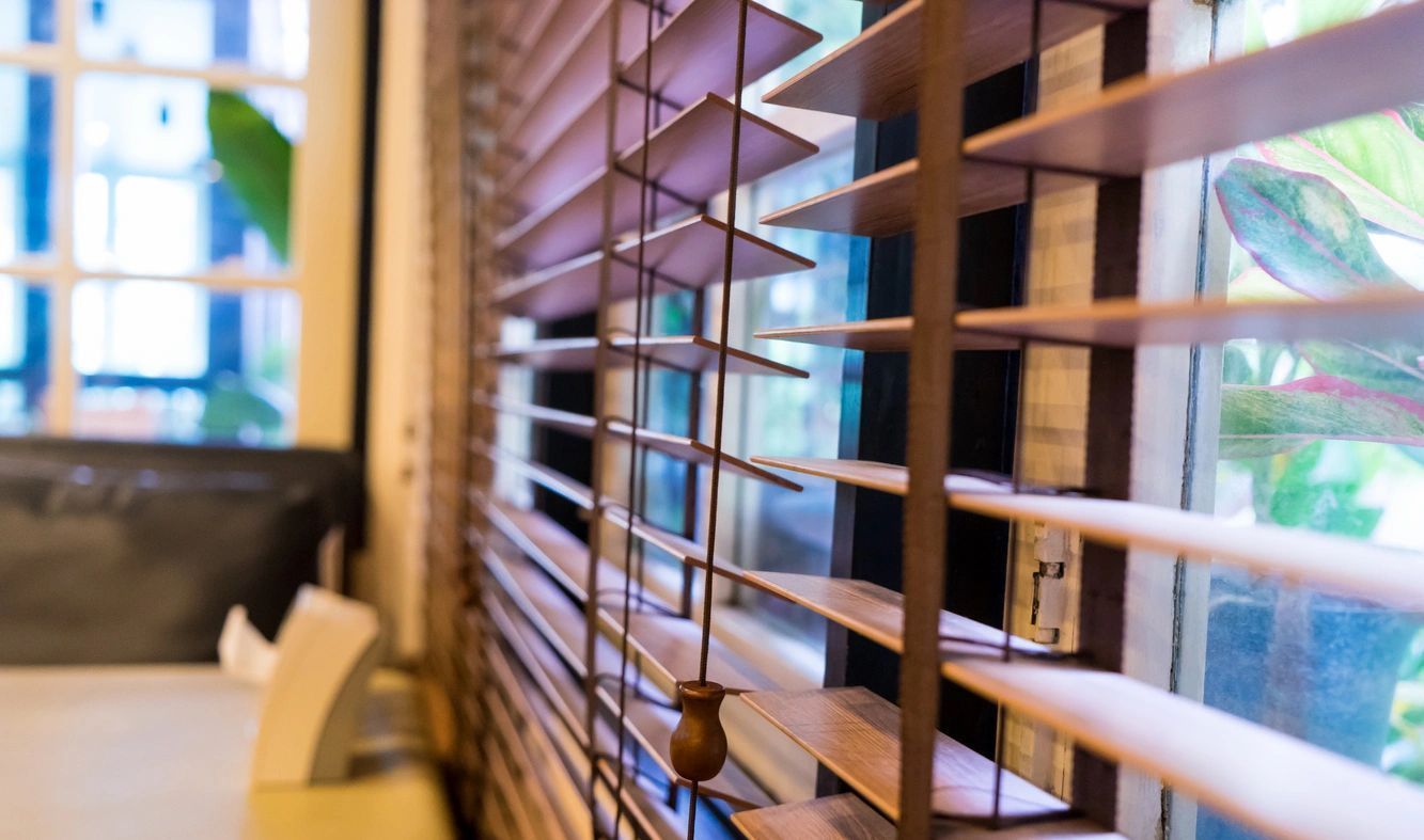A close up of a window with wooden blinds on it