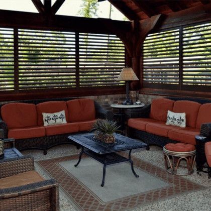 A living room with a couch, chairs, a table and a lamp