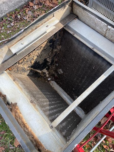 Open rooftop hatch with dark interior and metal frame, viewed from above.