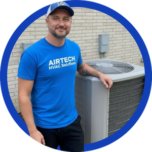 HVAC technician in blue shirt standing beside an outdoor air conditioner unit