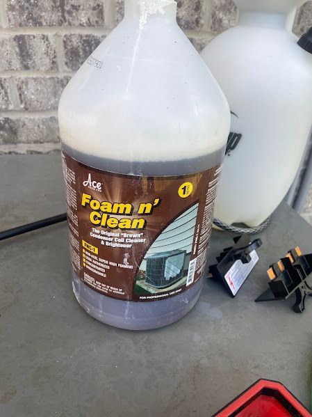 Bottle of Farm n Clean detergent on a concrete floor, with tools and containers in the background