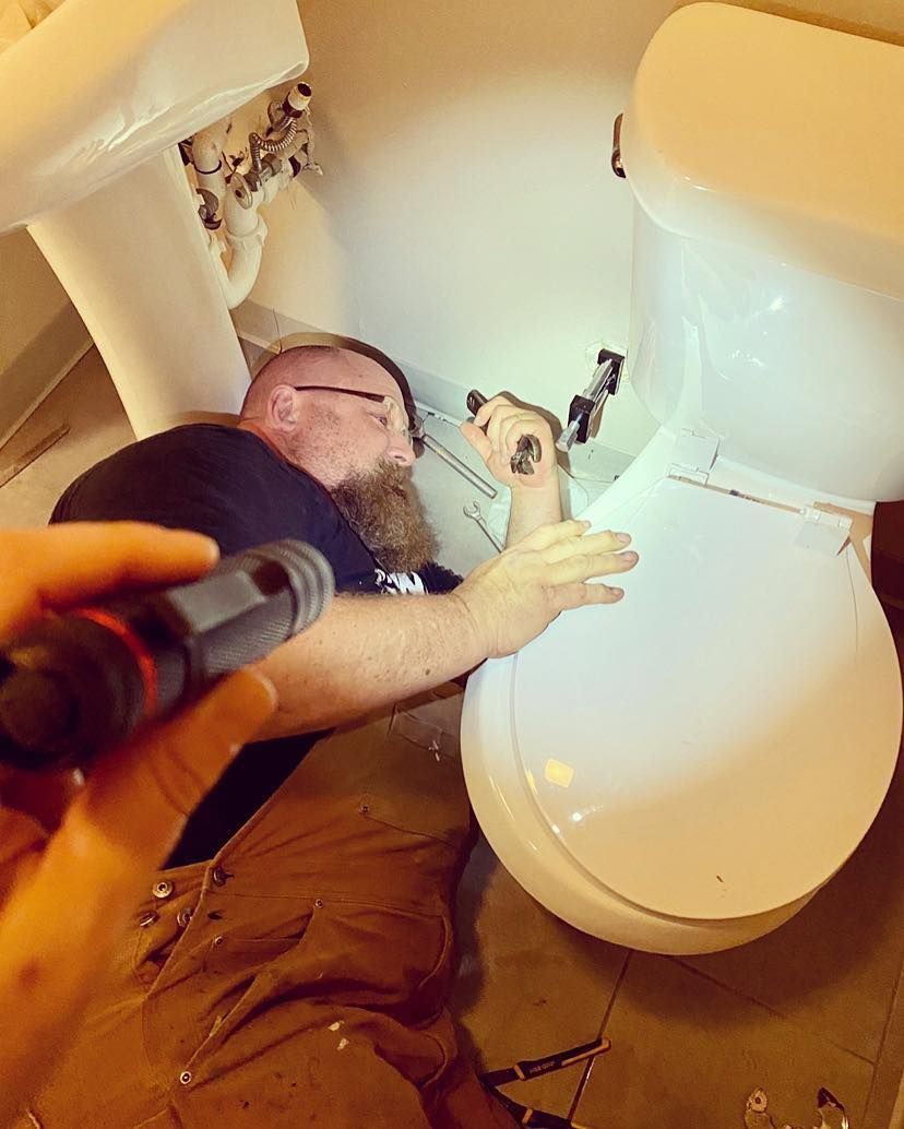 Person using a flashlight to inspect a broken white chair or toilet in a cramped indoor space