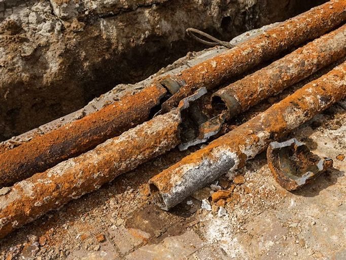 Rusty cast iron sewer pipe showing corrosion and deterioration
