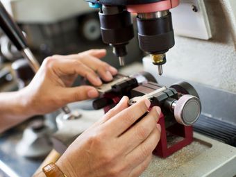 Hands cutting a key on a key duplicating machine.
