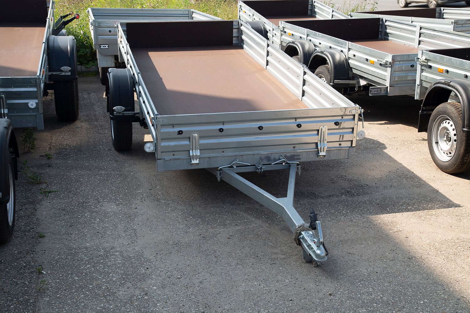 Flatbed utility trailers parked in a lot, ready for hauling equipment or materials. Flatbed utility trailers parked in a lot, ready for hauling equipment or materials.