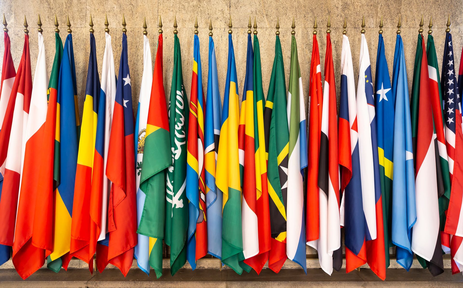 Multiple international flags displayed in a row. Multiple international flags displayed in a row.