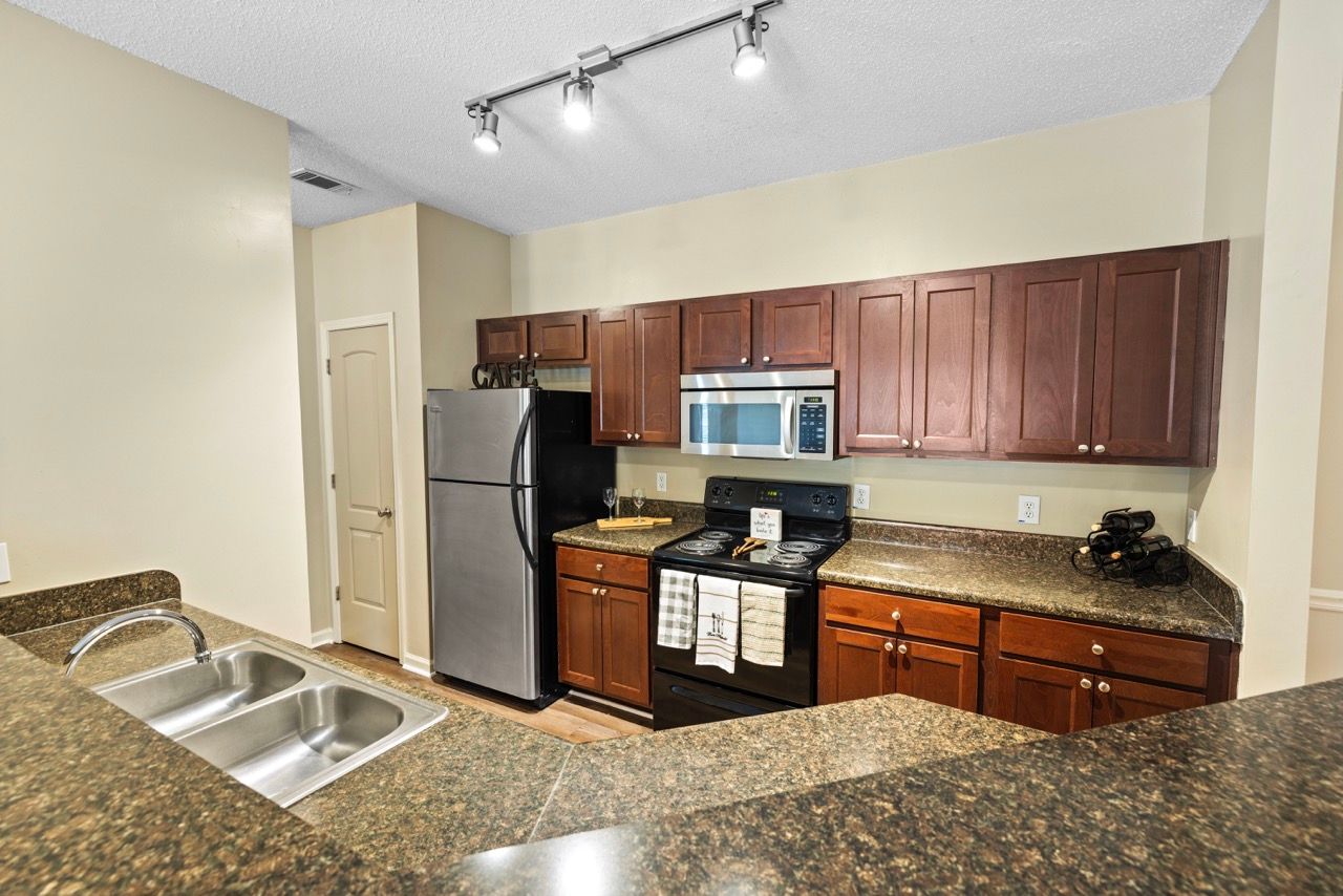 Kitchen with granite countertops, dark wood cabinets, and stainless steel appliances.