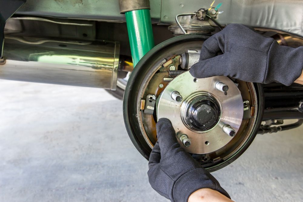 A Person Is Changing The Brake Pads On A Car — Valley Brake & Clutch In McDougalls Hill, NSW