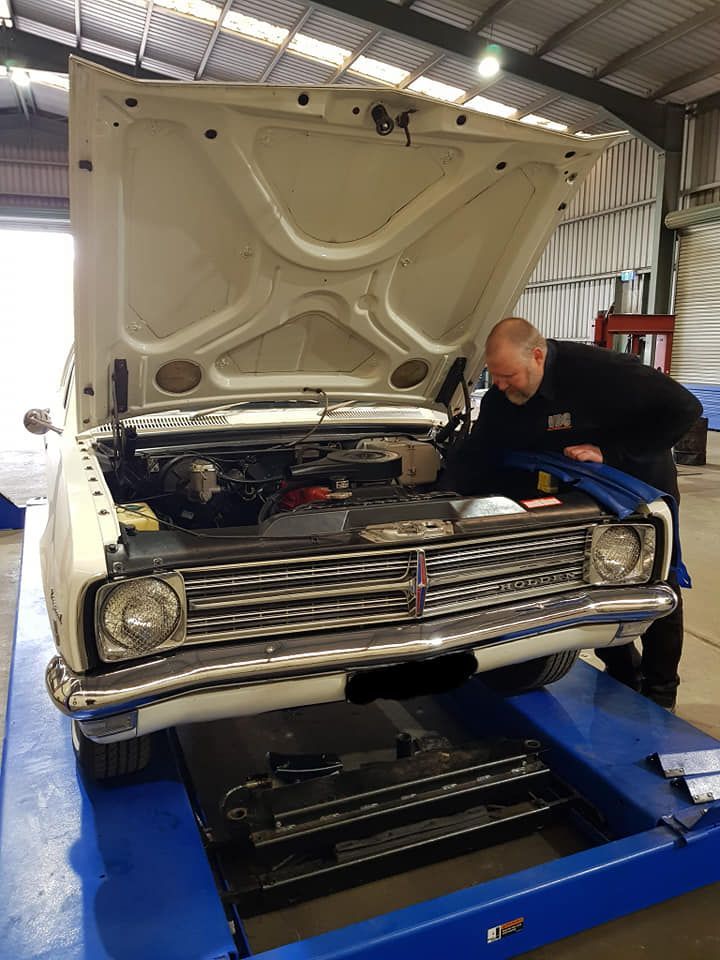A Man Is Working On A Car With The Hood Open In A Garage — Valley Brake & Clutch In Mcdougalls Hill, NSW