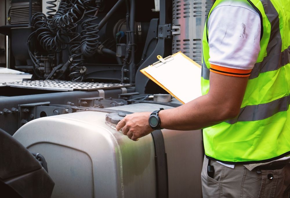 A Man In A Yellow Vest Is Standing Next To A Semi Truck Holding A Clipboard — Valley Brake & Clutch In McDougalls Hill, NSW