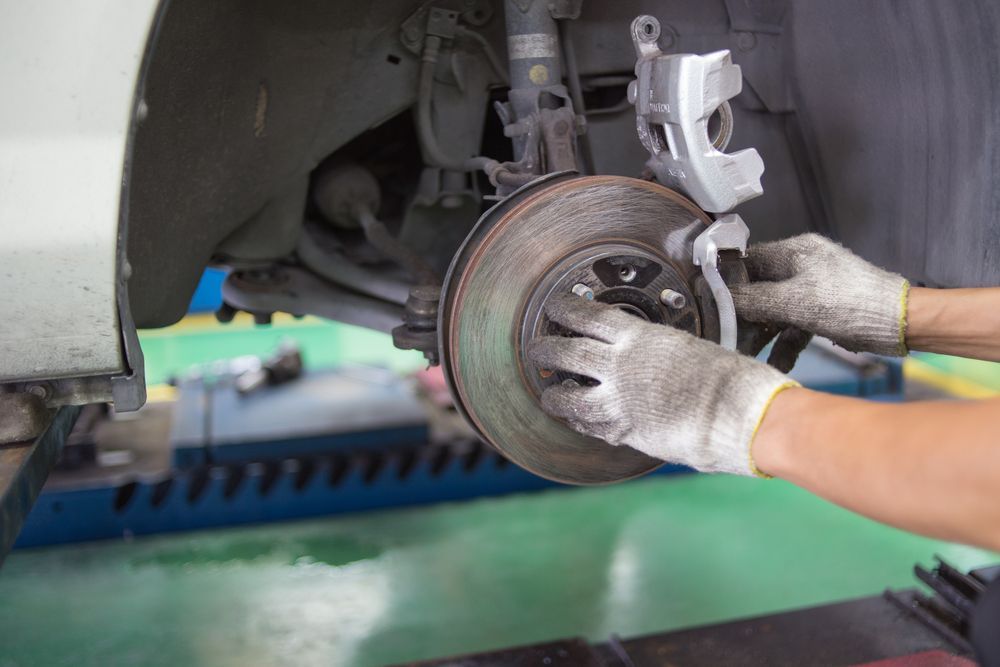 A Person Is Fixing A Brake Disc On A Car — Valley Brake & Clutch In McDougalls Hill, NSW