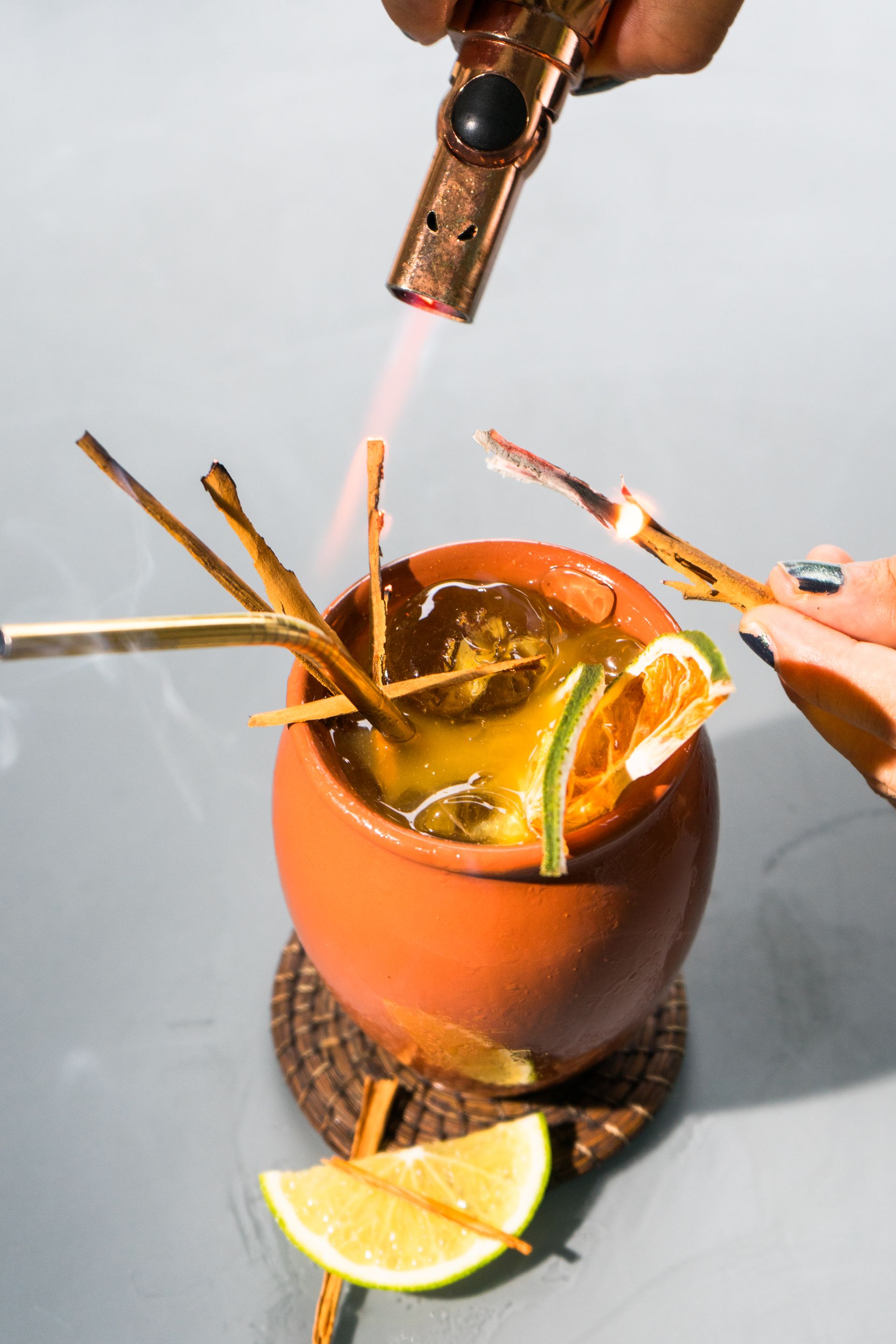 Se quema un cóctel en una olla de terracota con una guarnición.