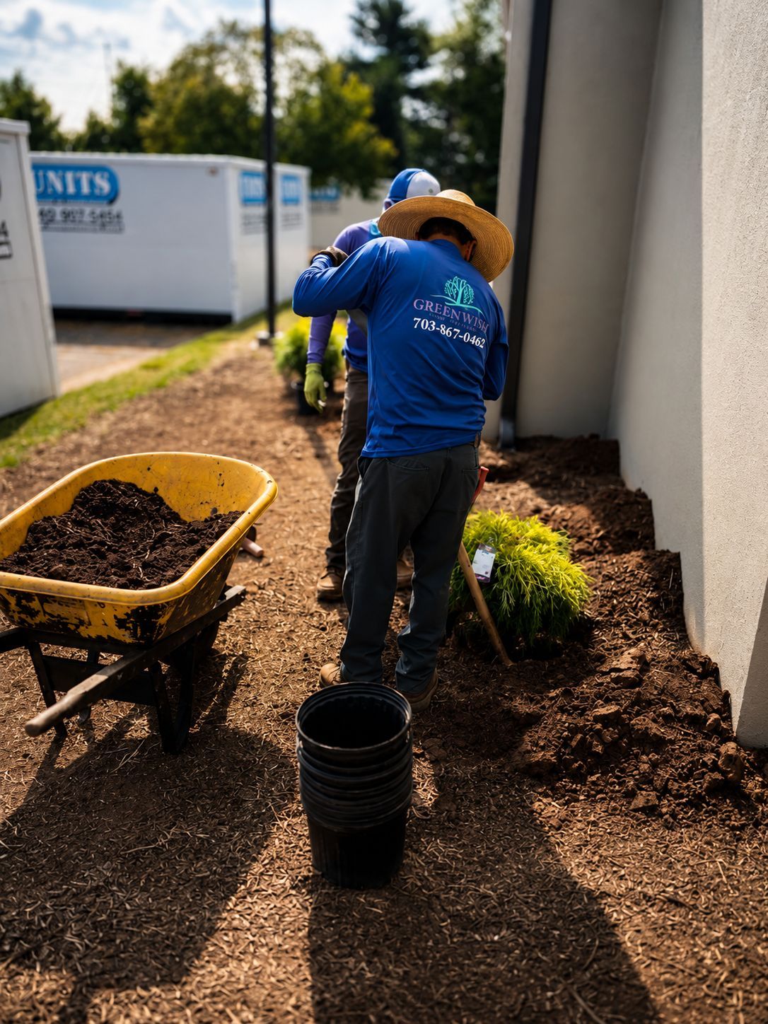 GreenWish Landscape & Masonry crew installing shrubs and landscape materials at a commercial property in Northern Virginia.