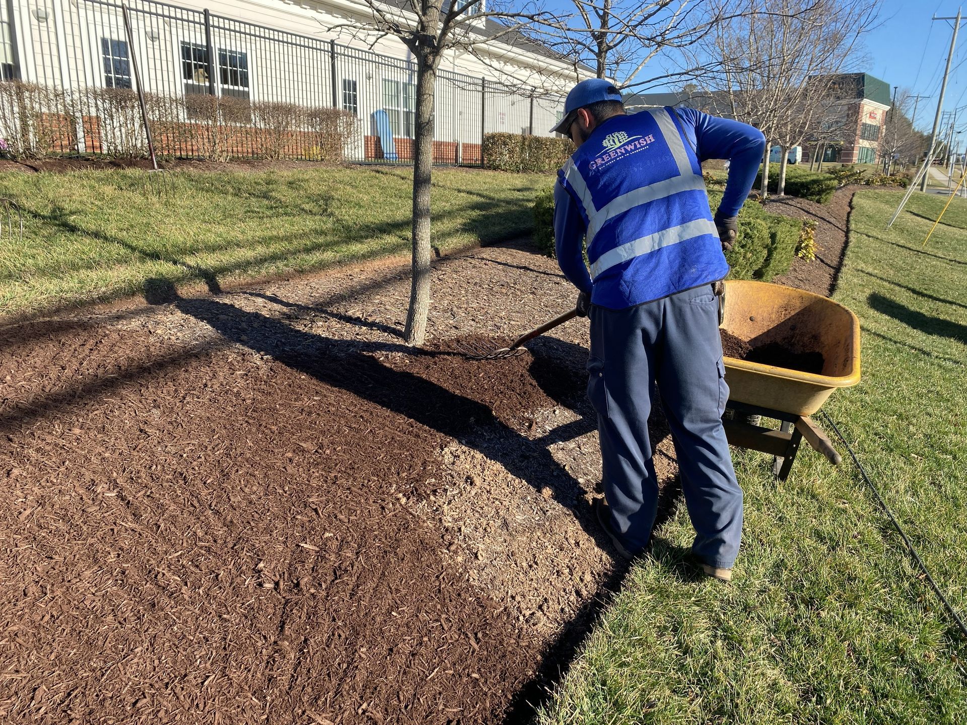 GreenWish Landscape & Masonry crew installing fresh hardwood mulch at a commercial property in Northern Virginia.