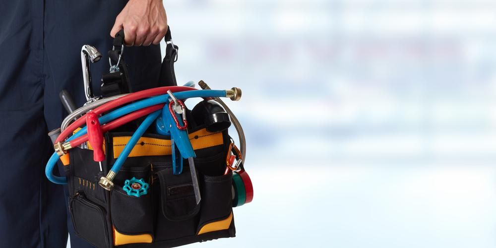 A Plumber is Carrying a Tool Bag Filled With Tools — Jet 'N' Drain Pty Ltd In Kawungan, QLD
