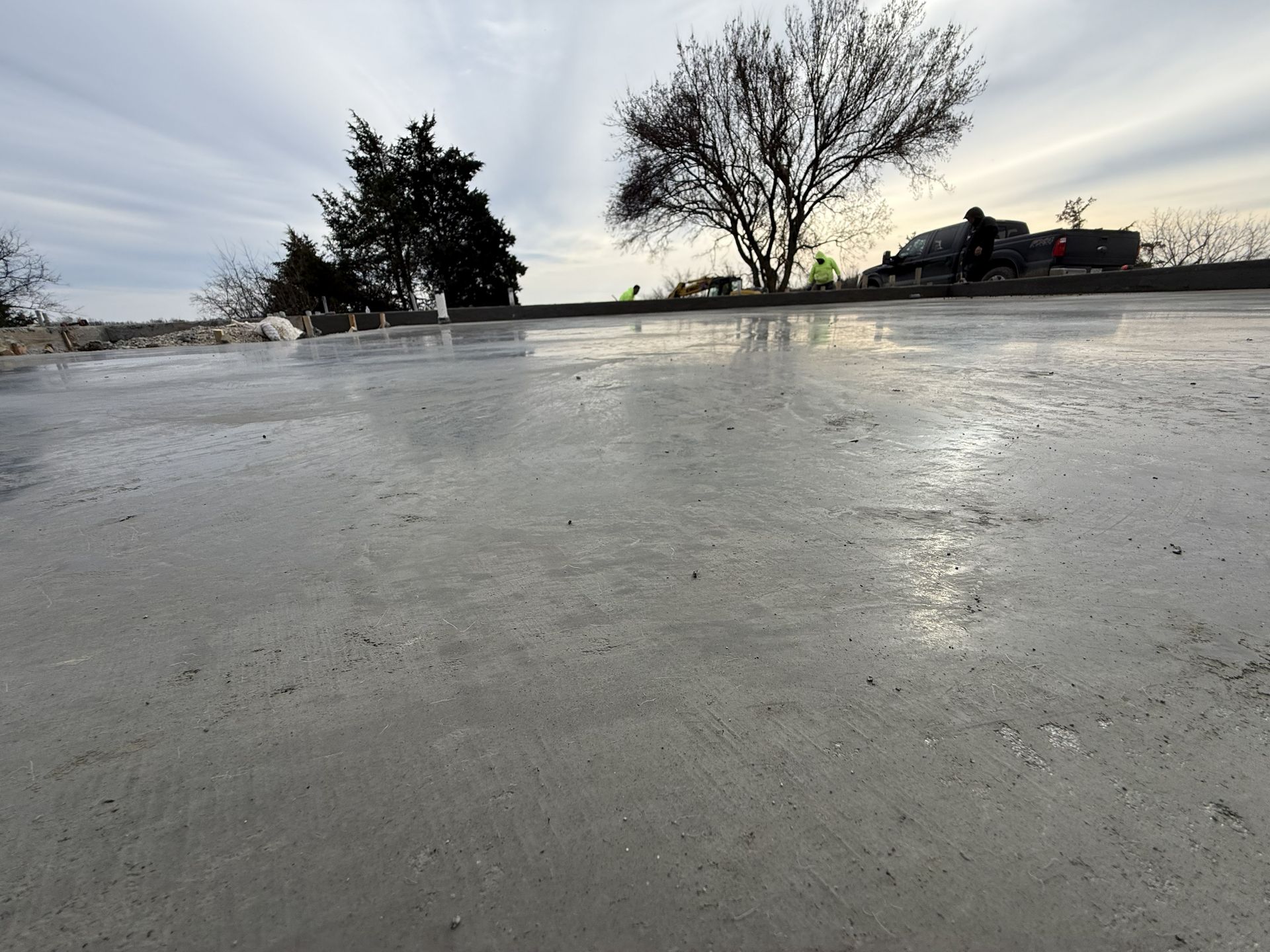 Icy frozen road at dusk with bare trees and a cloudy sky