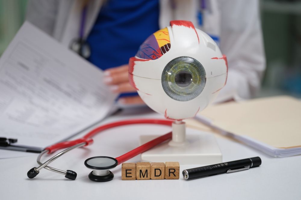 Eyeball model, stethoscope, and documents on a desk with the letters