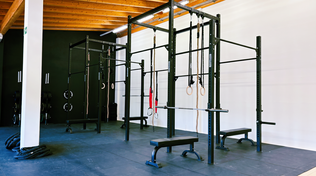Person exercising with red battle ropes in a foggy gym.