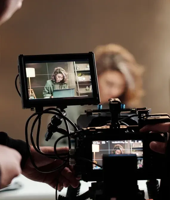 Camera rig filming a woman on a monitor, with a blurred subject in the background