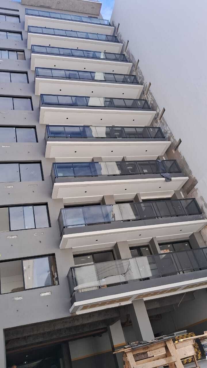 Edificio de varios pisos en construcción, balcones, exterior gris.