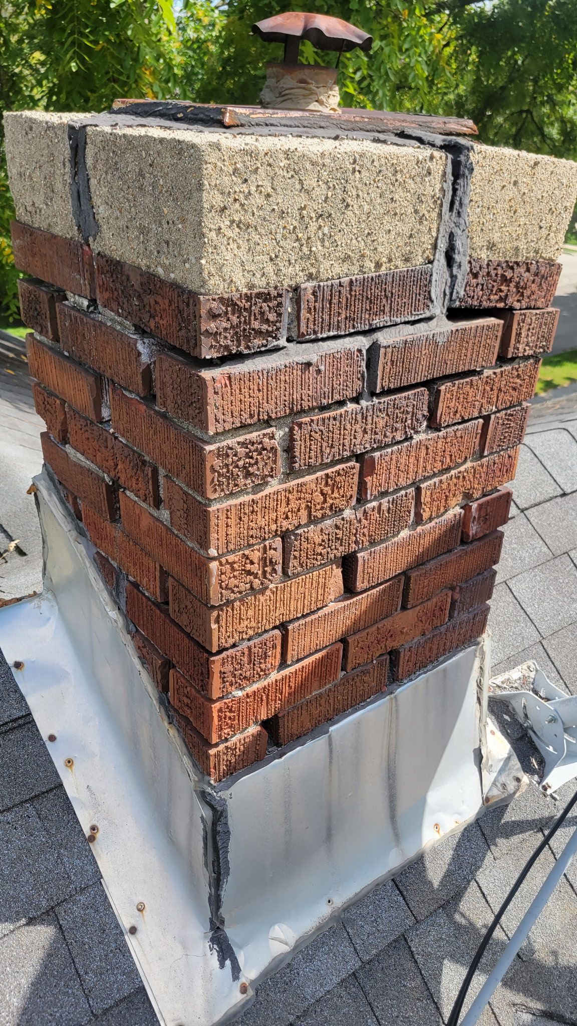 A brick chimney is sitting on top of a roof.