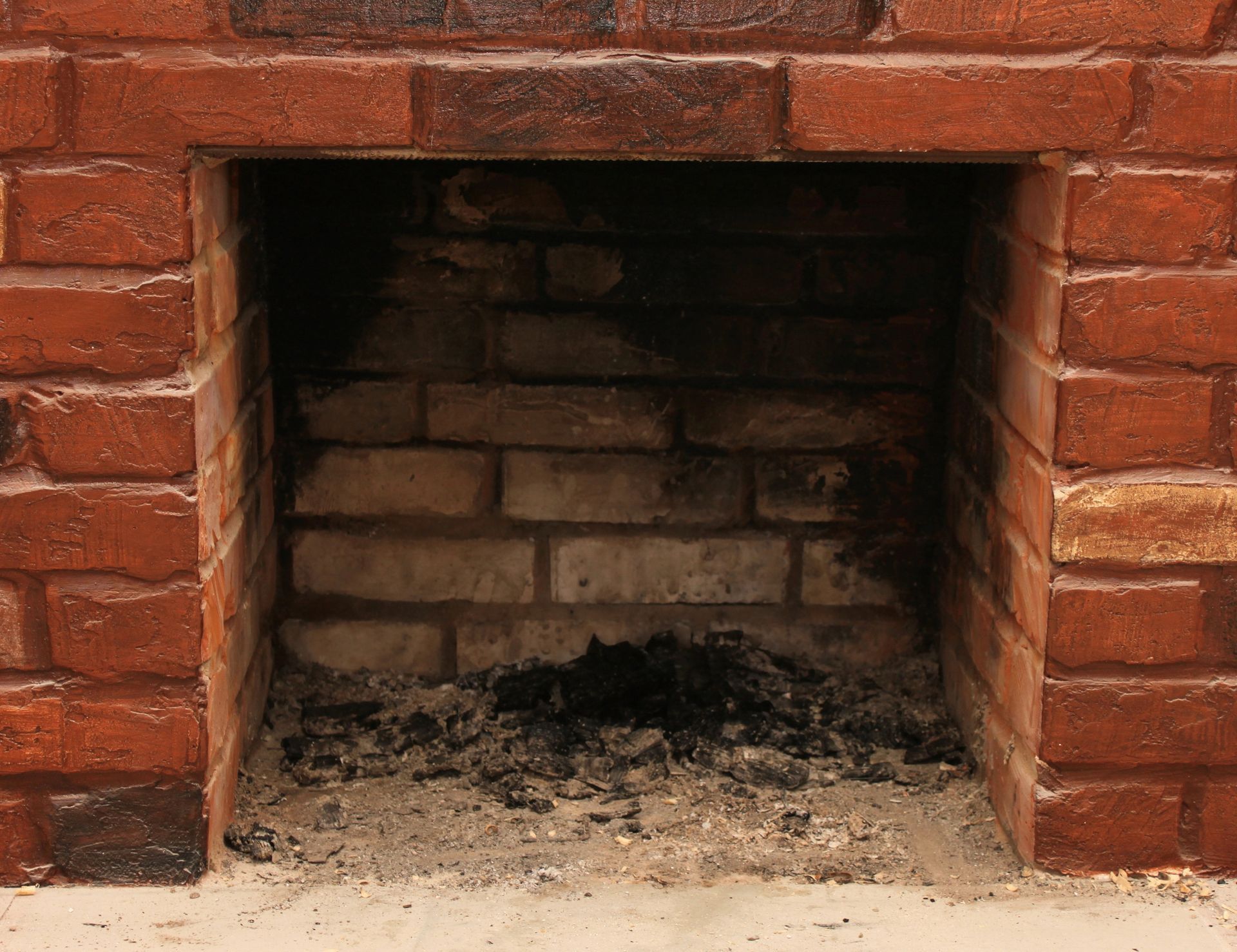 Brick fireplace with ash residue inside.