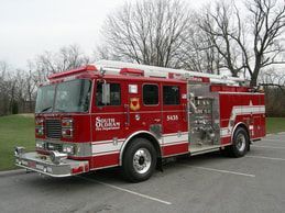 A red fire truck is parked in a parking lot.