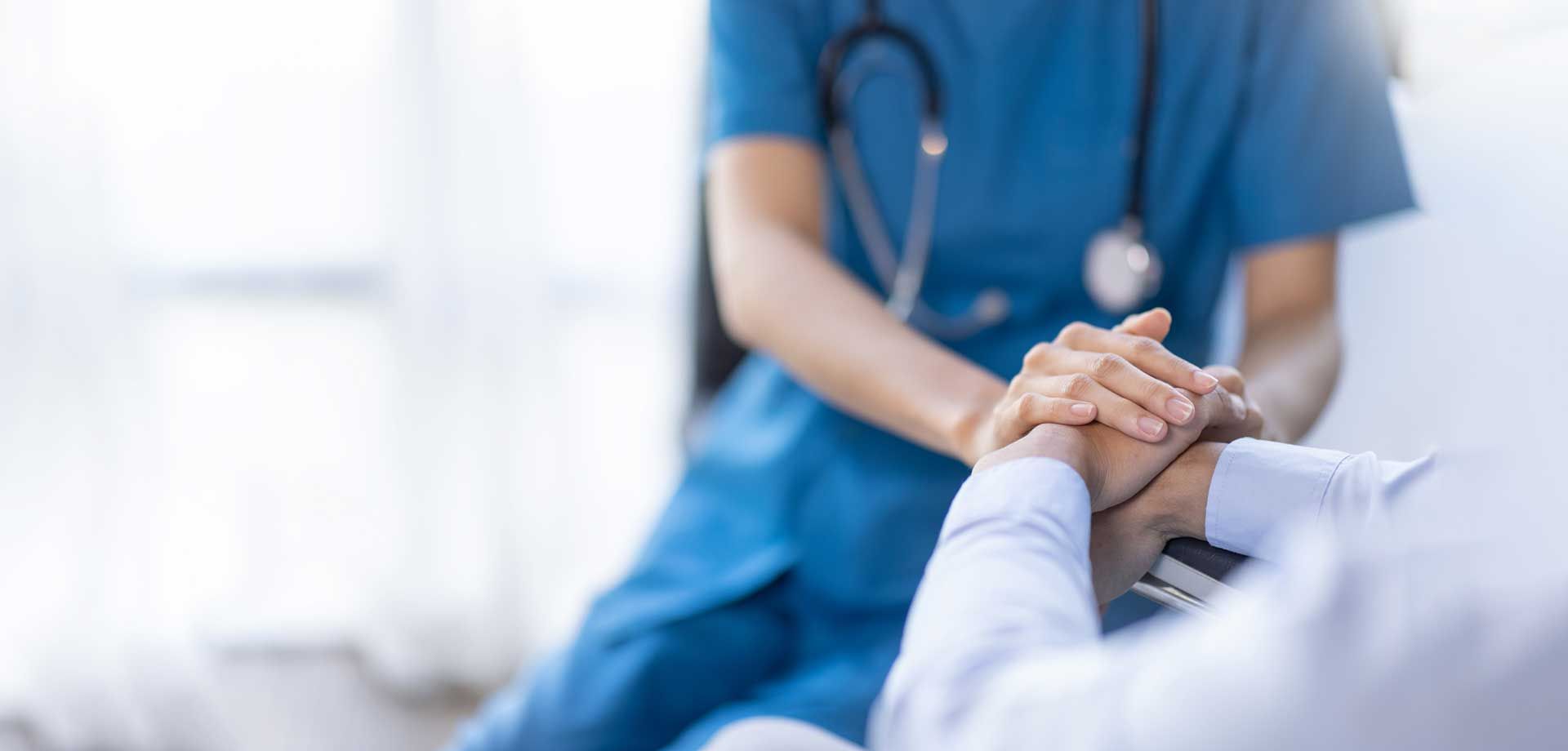 Doctor holding hands with patient