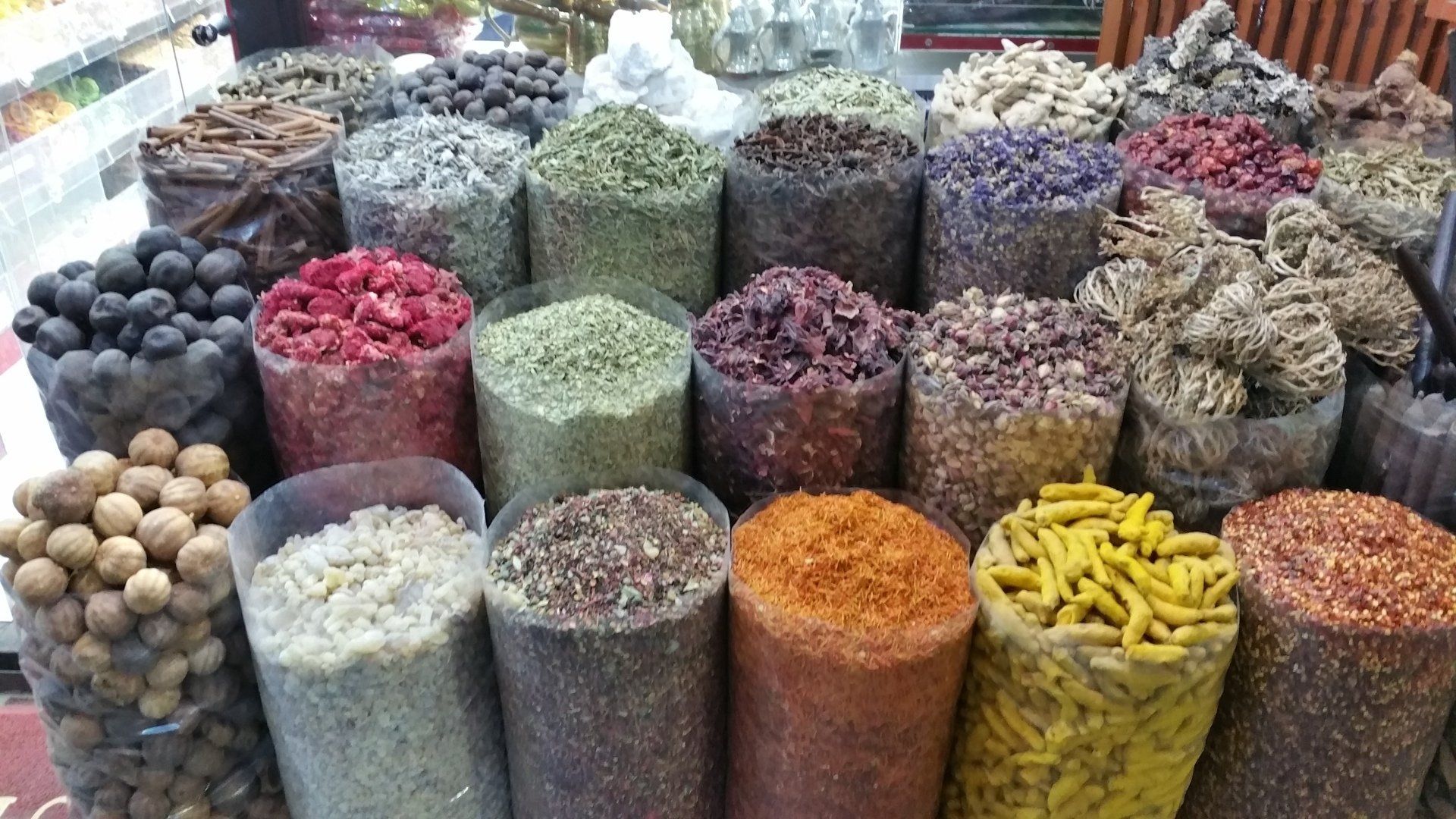 Zakken met kleurrijke specerijen uitgestald op een markt.