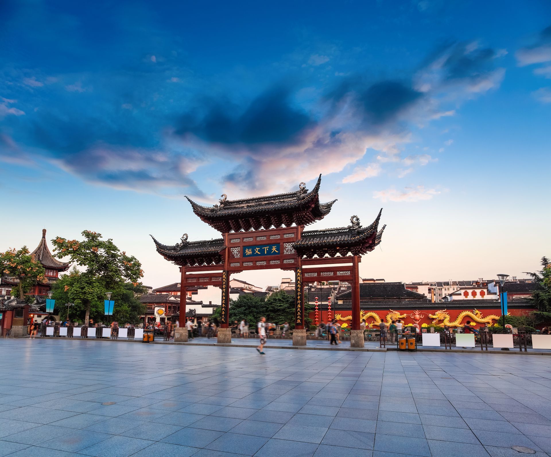 Traditionele Chinese poort met rode en zwarte accenten, onder een schemerige hemel.
