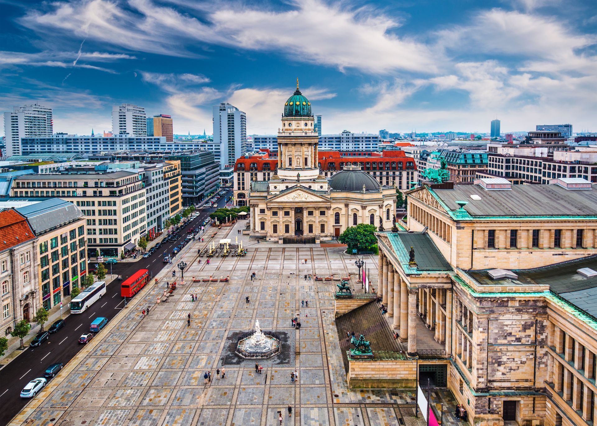 Luchtfoto van het Gendarmenmarktplein in Berlijn, met neoklassieke gebouwen, voetgangers en een blauwe lucht.
