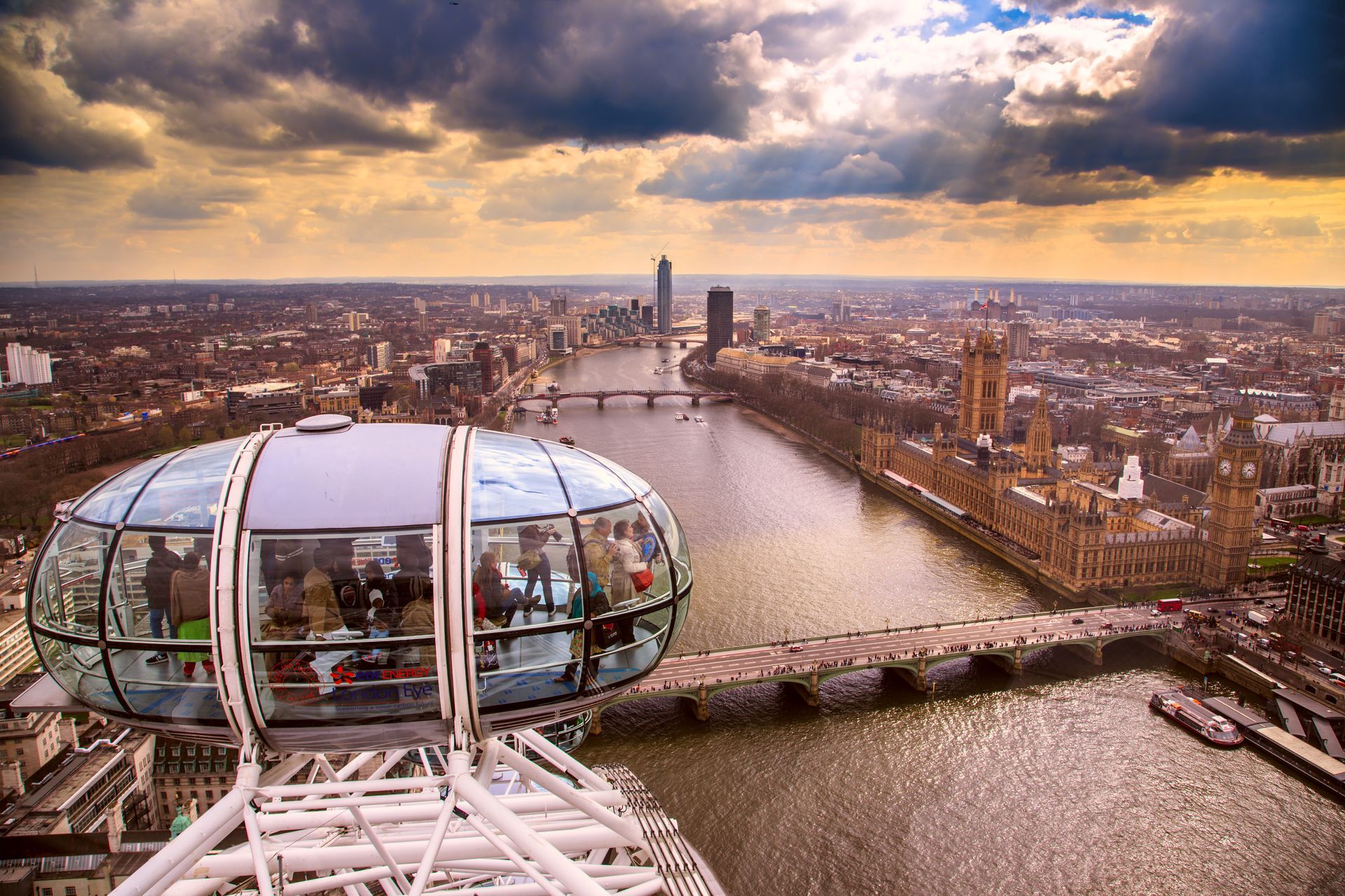 De capsule van het London Eye biedt uitzicht op de stad: de Theems, het parlementsgebouw en een bewolkte hemel.