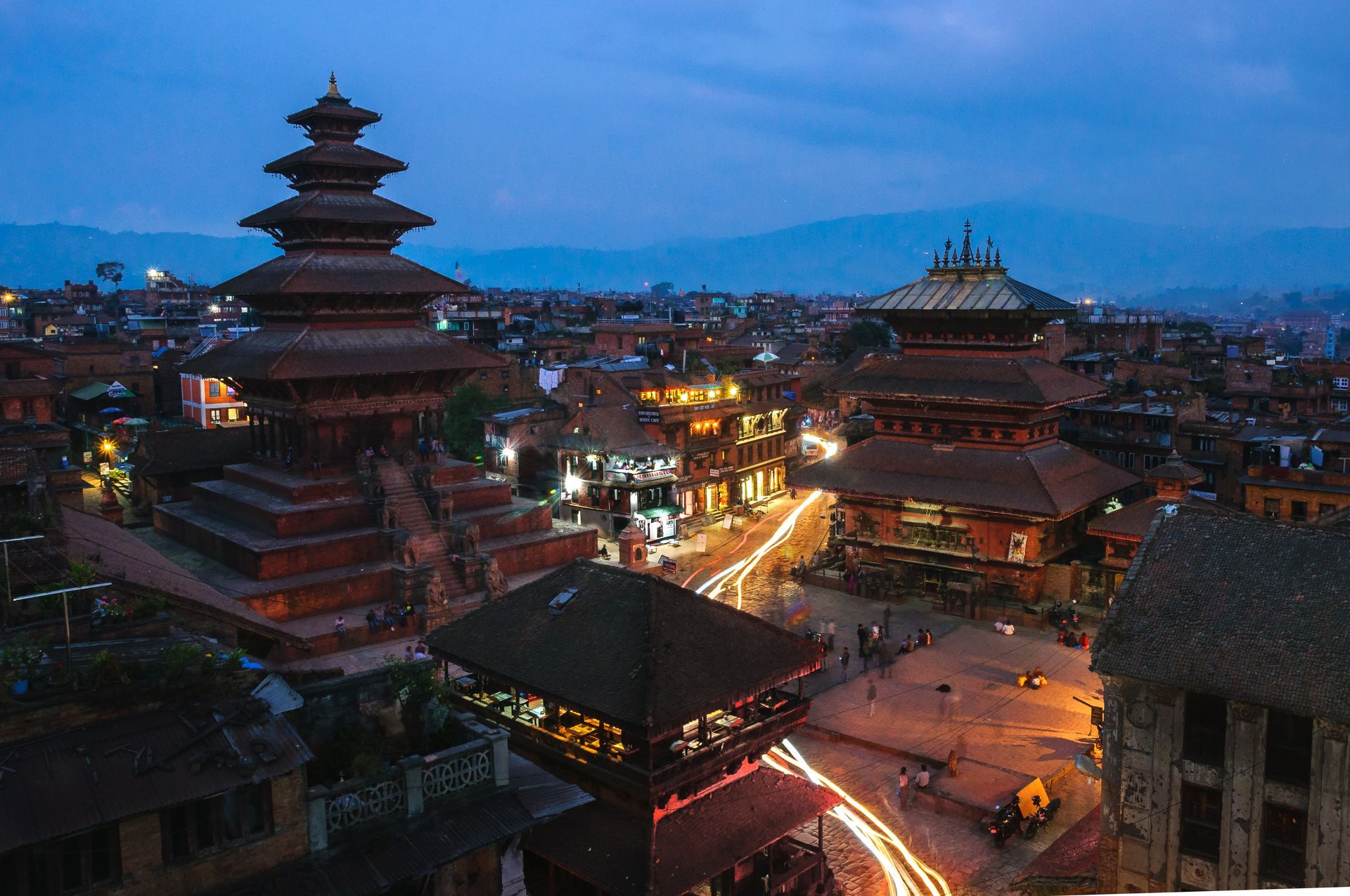 Nachtzicht op het Bhaktapur Durbarplein in Nepal, met verlichte tempels en gebouwen, vastgelegd met lange belichtingstijd en lichtsporen.