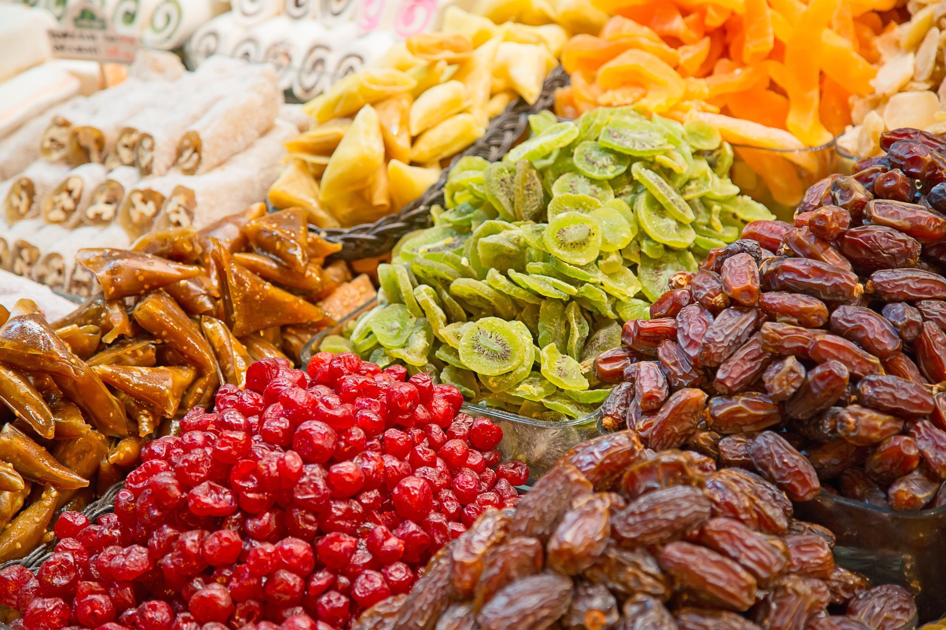 Een assortiment kleurrijke gedroogde vruchten: kiwi, dadels, kersen, abrikozen en Turks fruit.