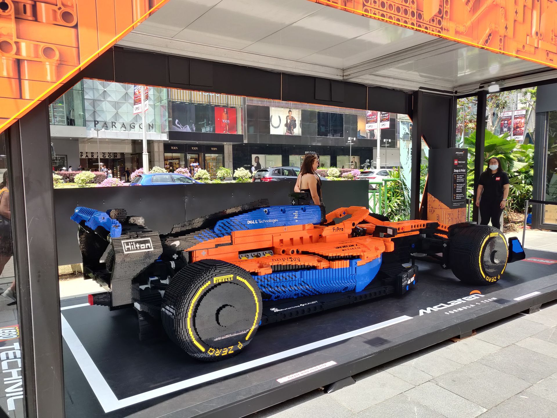Een McLaren Formule 1-auto, gebouwd van Lego-stenen, staat buiten tentoongesteld in een openbare ruimte.
