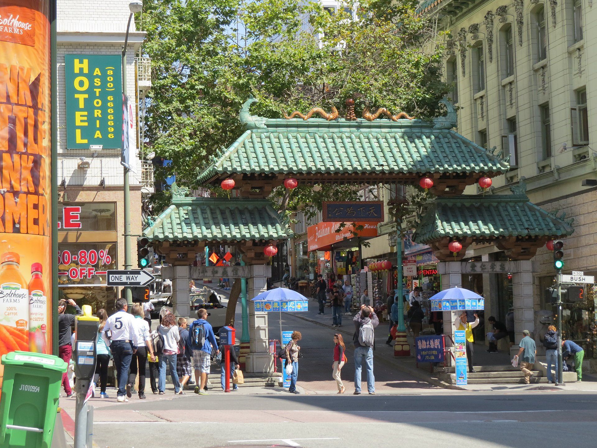 De poort van Chinatown in San Francisco met mensen, winkels en een hotelbord.