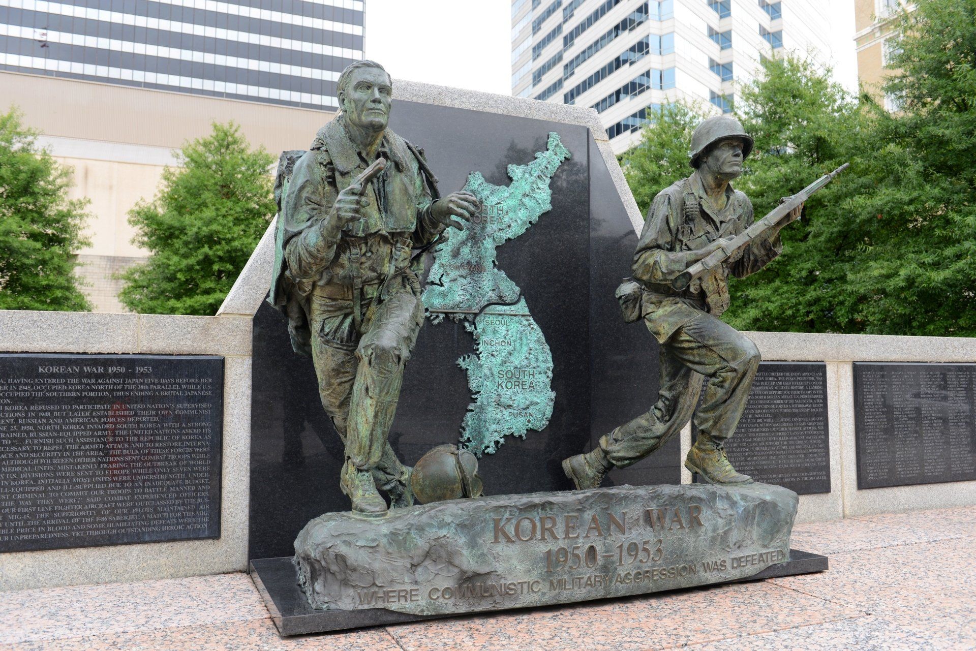Bronzen monument ter nagedachtenis aan de Koreaanse Oorlog, met soldatenbeelden, een kaart van Korea en gegraveerde tekst.